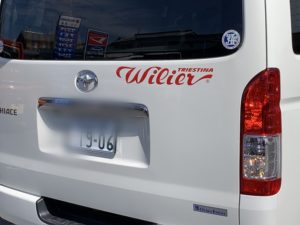 ガラス越しに弊社の自動車部門の看板が映り込み。